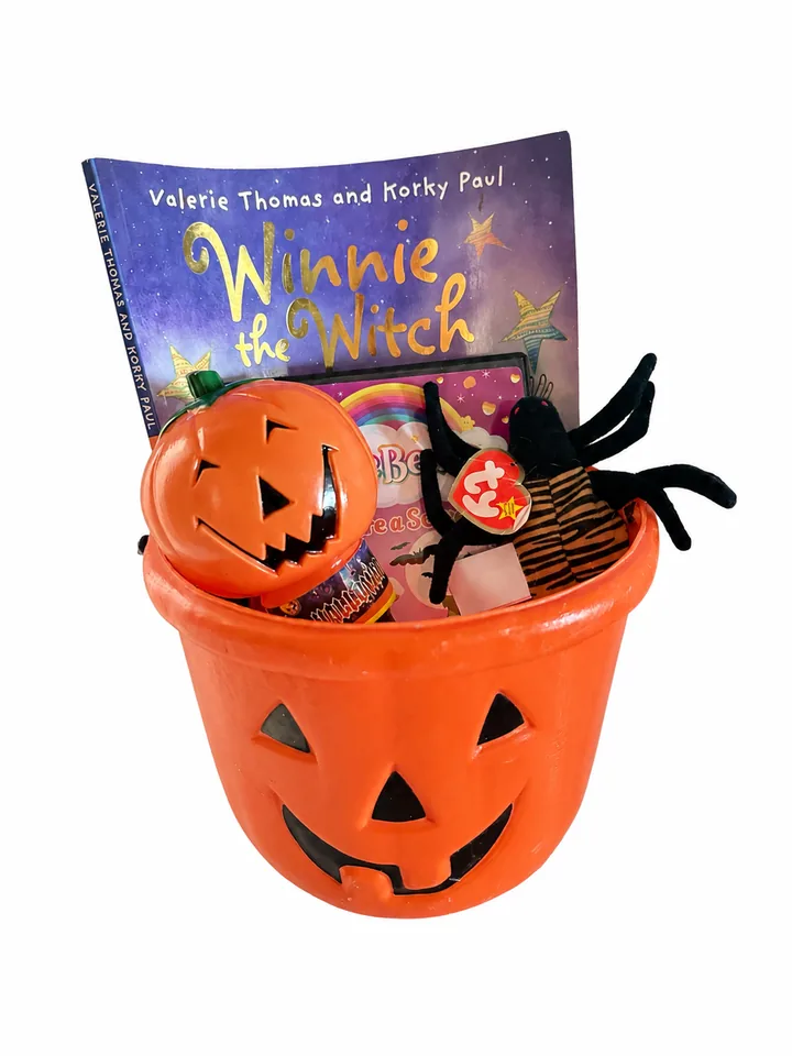 A jack-o-lantern pail packed with a Winnie the Witch picture book, a Ty plush spider, a small pumpkin bucket and sweets.